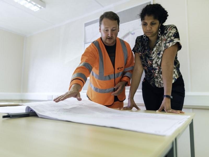 Equipo técnico en reunión con documentos del proyecto.